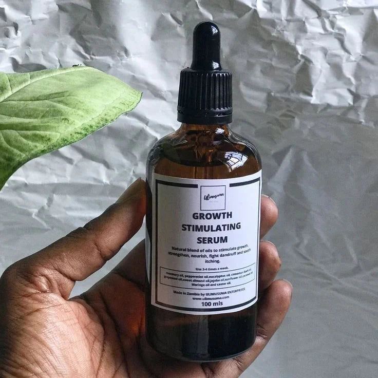 Hand holding a bottle of 'Growth Stimulating Serum' against a crumpled paper background.