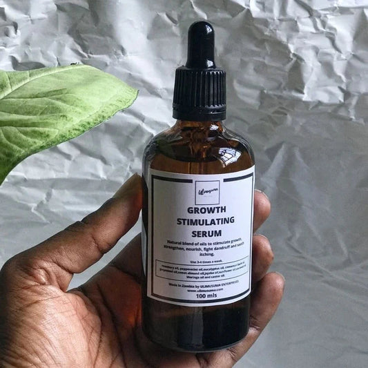 Hand holding a bottle of 'Growth Stimulating Serum' against a crumpled paper background.