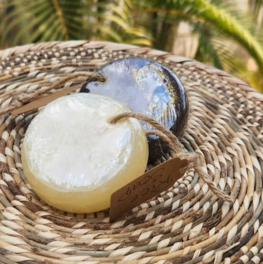 Bar of soap on a woven surface with blurred greenery in the background