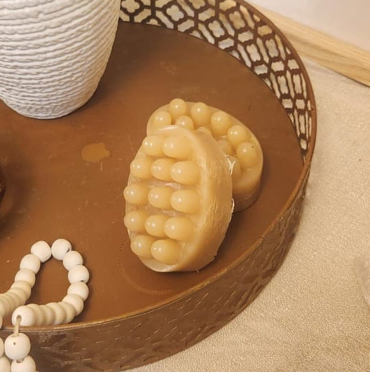 Decorative tray with a vase, decorative items, and a plant on a surface.